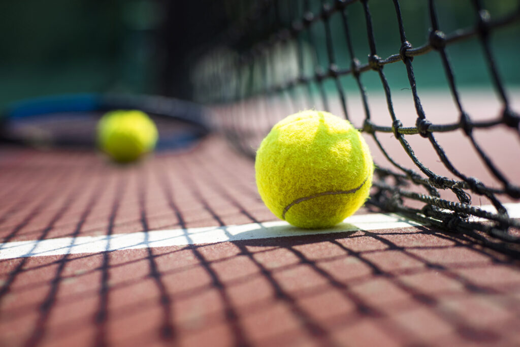 Palline da tennis e rete su un campo in terra rossa