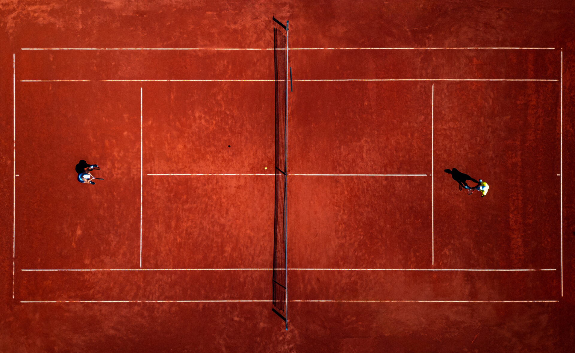 Due tennisti in azione su un campo in terra rossa